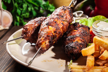 Grilled shish kebab served with fried chips and salad