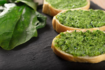 Bruschetta with pesto sauce on a slate plate