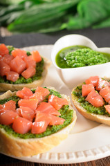 Bruschetta with salmon and pesto sauce on a slate plate