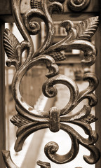 Wrought iron railing. Shapes of leaf and elegant curves. Sepia toned image. 