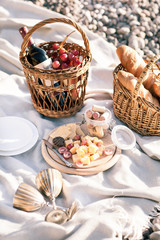 Picnic background with basket, wine and fruits by the ocean