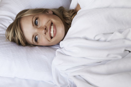 Beautiful blond in bed smiling