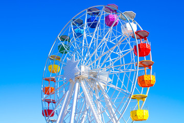 Multicolour ferris wheel on blue sky background	 - Powered by Adobe