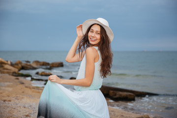 Happy attractive young woman walking on the beach