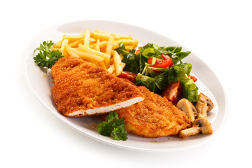 Fried pork chop, French fries and vegetables 