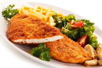 Fried pork chop, French fries and vegetables 