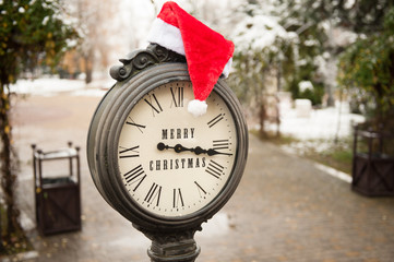 vintage clock with santa hat and the words Merry Christmas
