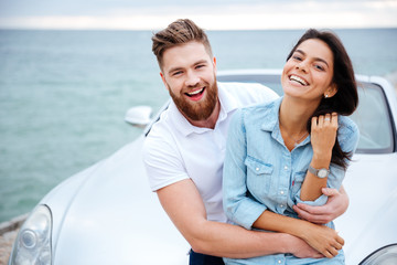 Couple on a date standing near car at the seaside