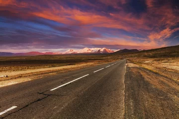 Papier Peint photo Sécheresse Picturesque fiery sunset over the cracked desert road