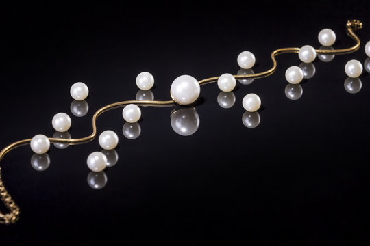 White pearls necklace on black background