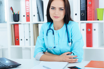 Young female doctor is waiting for patient to examine. Physician reception concept.