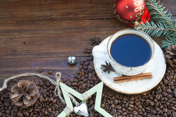 A cup of coffee. Coffee beans on the wooden background. Christmas still life.