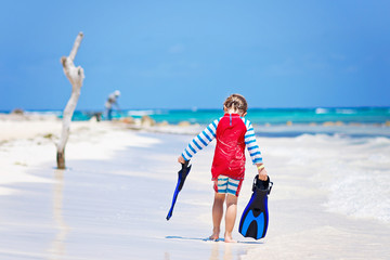 little blond kid boy having fun on tropical beach of Maldives