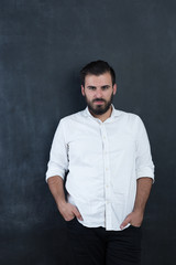 Portrait of a  young bearded man against black chalkboard