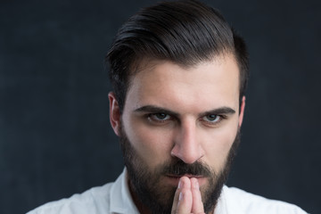 Portrait of a  young bearded man against black chalkboard