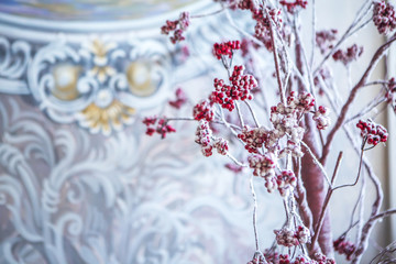 Дерево рябины с красными ягодами в снегу на фоне бело-синего узора на стене