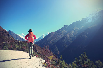 Obraz premium young woman backpacker trekking on himalaya mountains