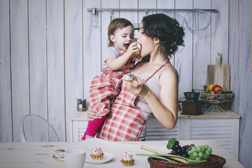 Mother and small child in the kitchen at home beautiful and happ