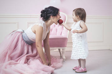 Mother and daughter a beautiful and happy pink interior with vin