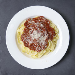 A dinner dish of spaghetti Bolognese on a rustic slate background