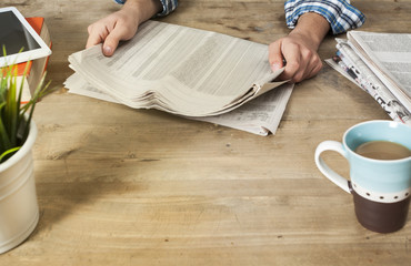 Fototapeta na wymiar Reading newspaper on wooden table