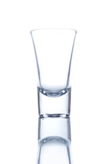 Vodka glass isolated on white background with a reflection.