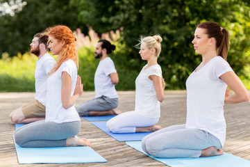 people making yoga in hero pose outdoors