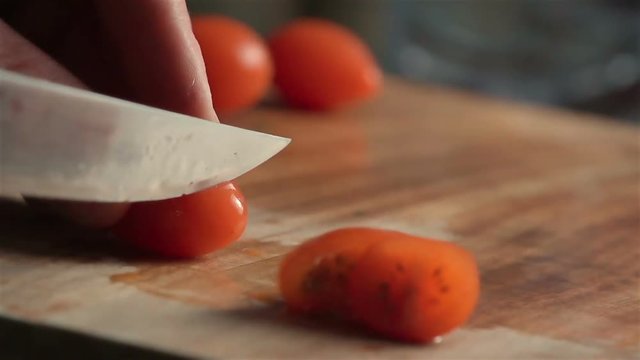 Slow motion of little tomatoes slicing. Find similar in our portfolio.