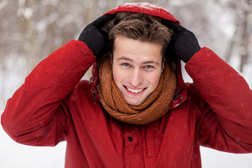 happy man in winter jacket with hood outdoors