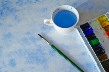 watercolor box, a brush on an abstract blue figure