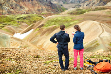 Fototapeta premium couple hikers National Park Landmannalaugar, Iceland. woman resting and eating figs
