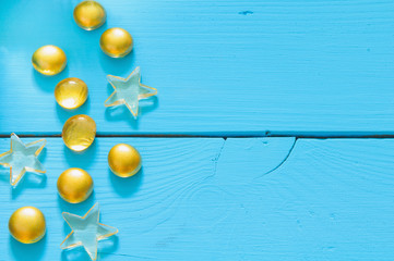 Close up image of yellow marbles on blue wooden background