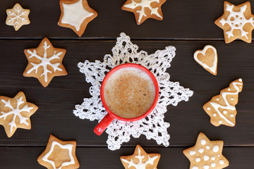 festive coffee break/ flat layout with red mug full of frothy coffee, surrounded by a shaped cookies top view 