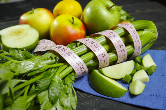 Green vegetables and fruits -  celery shoots and  apples, dietary concept