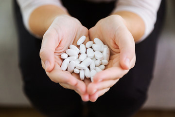 Both hands holding bunch of pills. Overdose or abuse concept.