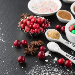 Christmas baking cupcake decorations and sprinkles, black background, selective focus. Holiday concept