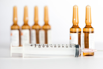 Injection syringe and brown ampule background