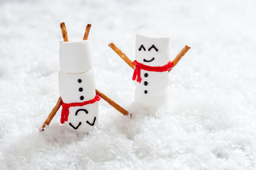 Happy funny marshmallow snowmans on snow
