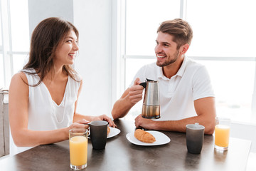Couple drinking coffee with croissants on the kitchen