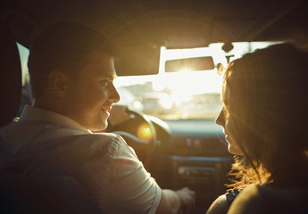 silhouette of couple in the sun for a moment before a kiss,wide angle in car 