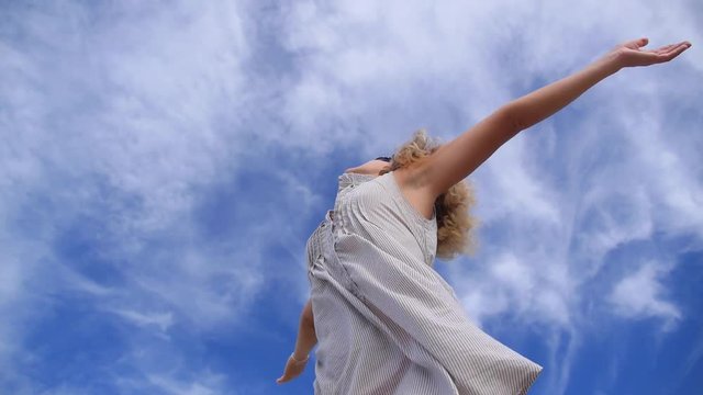 Happy Female with Arms Outstretched Against Sky