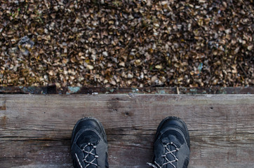 Men's shoes on the roof top with yellow leaves in autumn