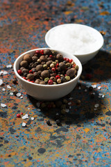 assortment of pepper and sea salt on a dark background, vertical