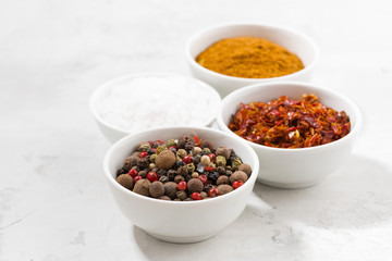 assortment of pepper, salt and spices in bowls