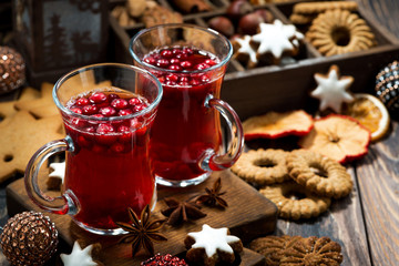 Christmas hot cranberry tea and cookies on dark table