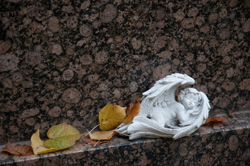 schlafende engelsfigur an einem grabstein