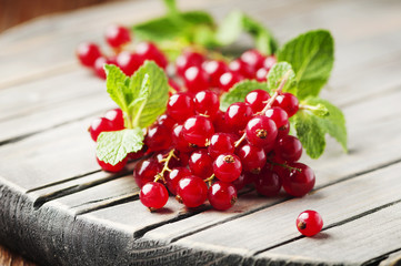 Red currant and mint on the wooden table