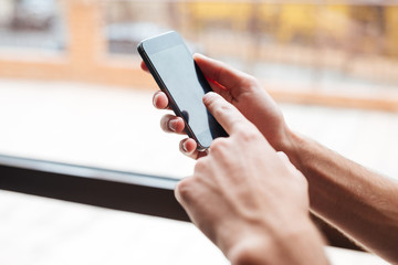 Hands holding smartphone device at gym