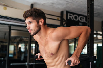 Fototapeta na wymiar Naked model doing exercises in the gym