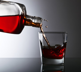bottle and glass of whiskey on a glass table